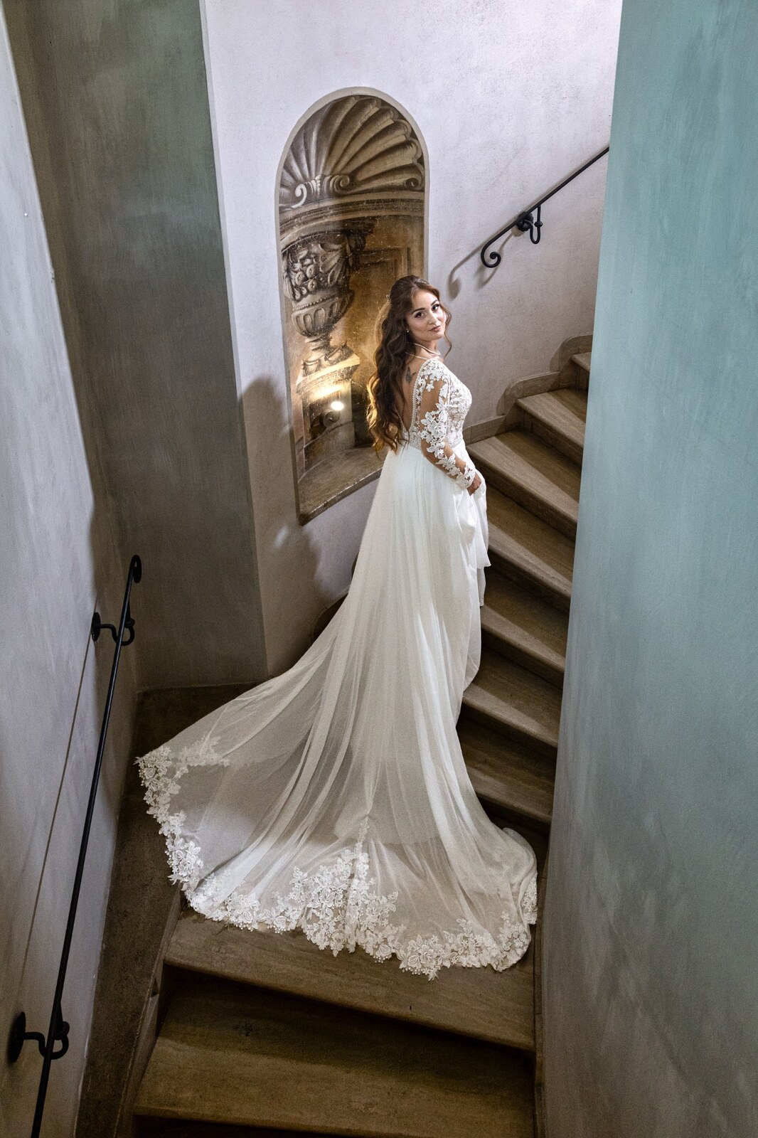 La sposa sulle scale con lo strascico dell'abito